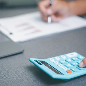 Person sitting at a desk working on a calculator