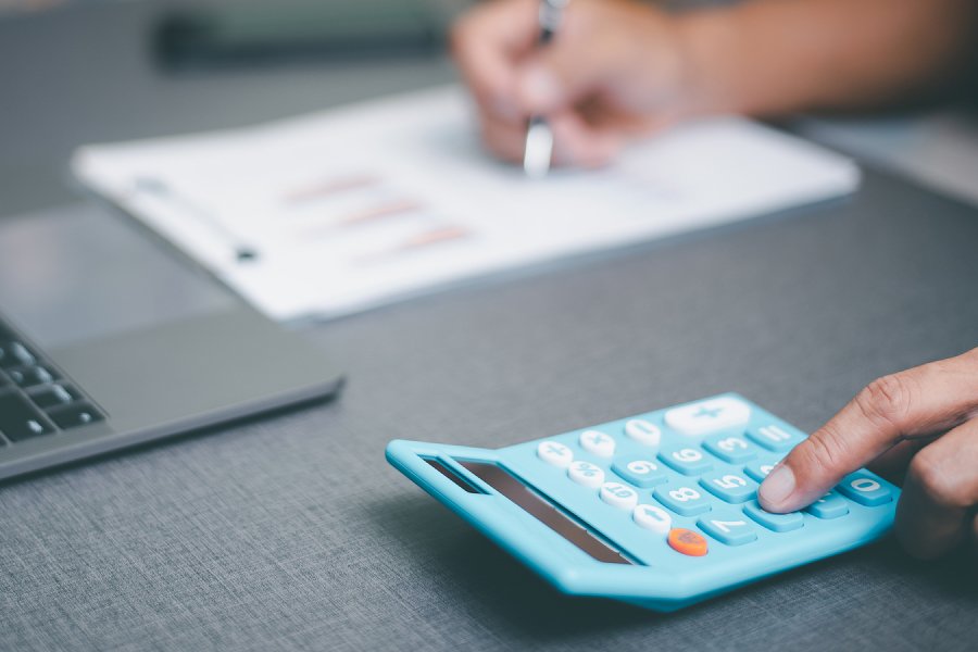 Person sitting at a desk working on a calculator